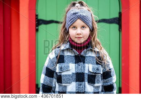The Girl Comes Out Through The Green Wooden Door Of A Colorful Playhouse