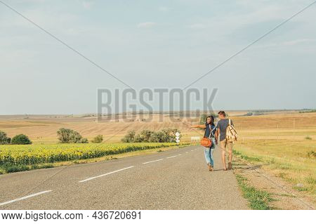 Hitchhiking. Thumb Up. Young Brunette Girl In A Denim Jumpsuit Is Hitchhiking Around Country. Free S