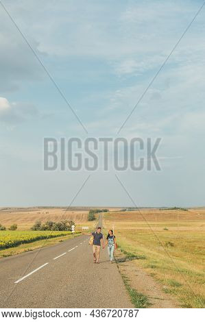 Young Guy And Girl Are Hitchhiking. Thumb Up. Concept - Adventure, Free, Freedom. Copy Space