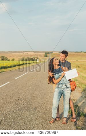 Lovers Guy And Girl Go Hitchhiking. In Hands Of Sheet With Inscription. Concept Adventures, Honeymoo