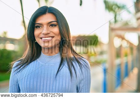 Beautiful hispanic woman smiling confient at the city