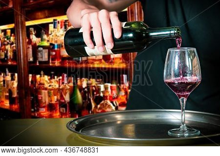 Bartender Putting Wine Into A Glass At The Bar On A Typical Metal Tray On The Bar Counter, In The Ba