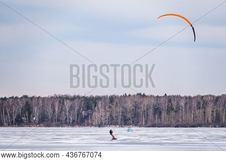 Kite Surfer Ride On Snowboard. Snowkiting In The Snow On Frozen Lake.