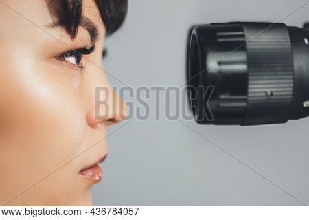 Ophthalmologist Doctor Woman Looking At Eyepiece. Ophthalmology. Close-up, Horizontally.