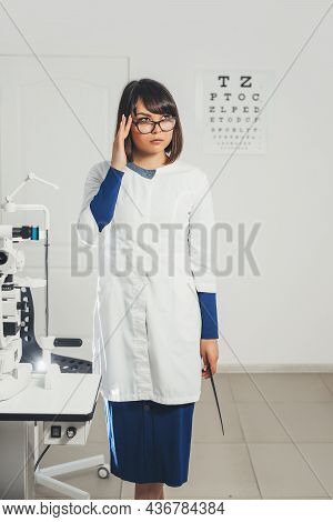 Doctor Ophthalmologist Holding Lenses To Check Patient's Vision. Focus On Lens, Face Is In Soft Focu