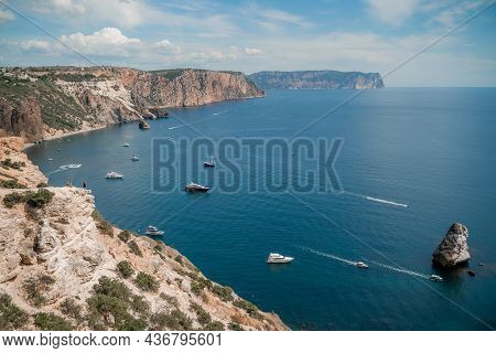 Two Rocks Stick Out Of The Water In The Middle Of The Turquoise Sea. Scenic Ocean View. Speed Boat S