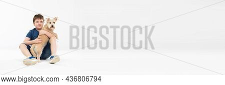 A Young Boy Is Sitting On A White Background And In His Hands He Is Holding His Beloved Dog. Panoram