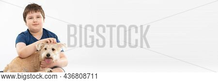 A Young Boy Holds His Dog In His Arms And Strokes It. Panoramic Frame. Subject Isolated From The Bac