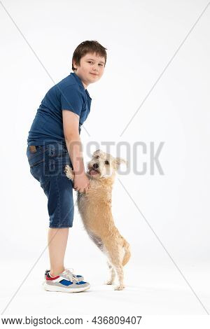 The Dog Is Standing On His Hind Legs And The Boy Is Holding Him By His Front Paws And They Are Both 