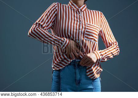 Girl Tucking A Striped Shirt Into Jeans Sexy Woman In A White T-shirt On A Gray Background. Mock-up.