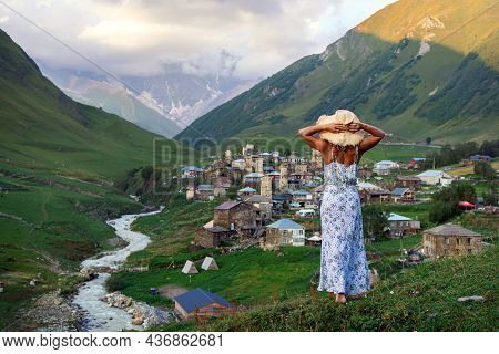 Young Beautiful Girl On The Edge Of A Cliff Looks At A Beautiful Mountain Landscape