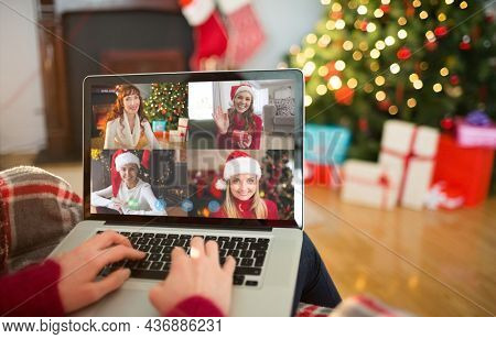Caucasian woman on christmas laptop video call with diverse group of friends. christmas, festivity and communication technology.