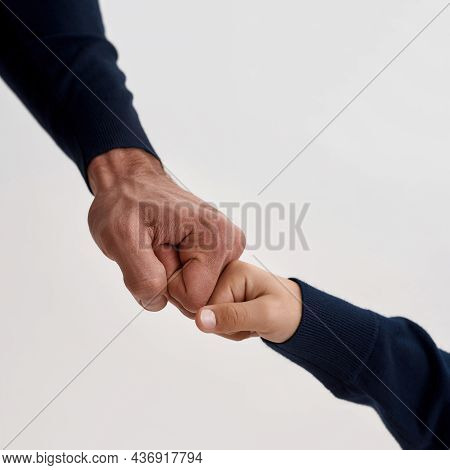 Narrow Vertical Crop Image Of Father And Small Son Give Fists Bump, Hands Isolated On White Studio B