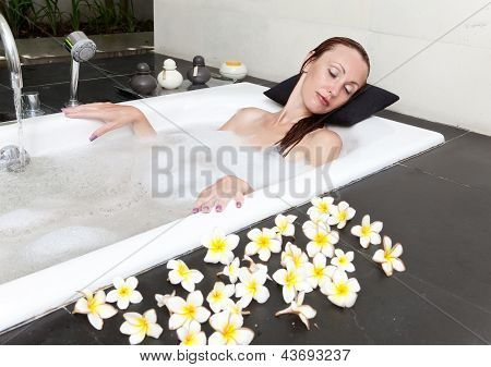 ผู้หญิงวางใน soapsuds ในการอาบน้ำที่เต็ม