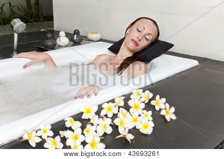 ผู้หญิงวางใน soapsuds ในการอาบน้ำที่เต็ม