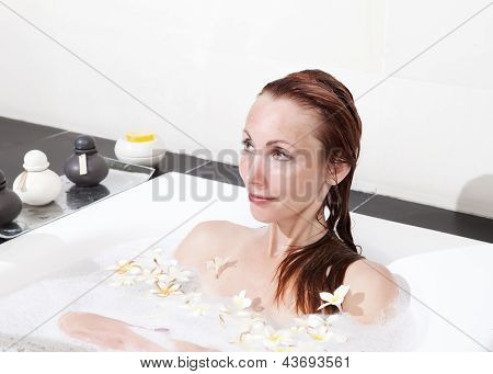ผู้หญิงวางใน soapsuds ในการอาบน้ำที่เต็ม