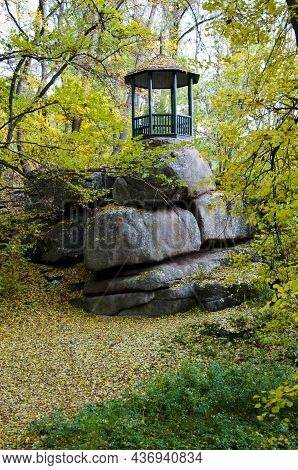 Alcove On Strony Rock In Autumn Nature Landscape With Lake Or Rives And Trees With Fallen Yellow Lea