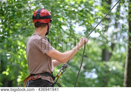 Man Belays His Partner Climber With Belaying Device And Rope. Climber's Handsman Holding Equipment F