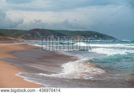 Beautiful Sandy Ocean Beach With Large Rocks On The Shore And In The Water. Powerful Waves On Ocean.