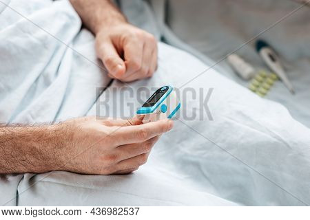 Patient Lying At Bed And Check The Data At Pulse Oximeter. Close Up Of Hands. Concept Of Determinati