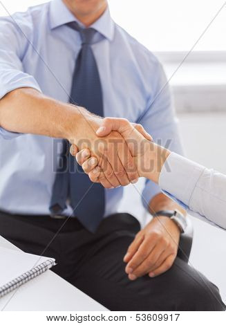 businesss and office concept - two businessmen shaking hands in office
