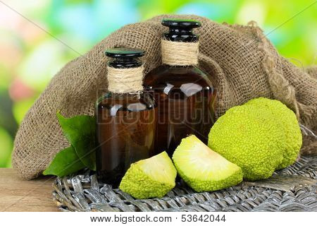 Osage Orange fruits (Maclura pomifera) and medicine bottles, on wooden table, on nature background