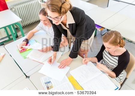 School Students or pupils having group work while geography lesson and the teacher test or educate them in class