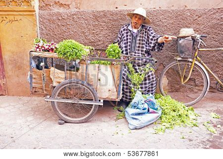MARRAKECH, MOROCCO - OCTOBER 22:Maroccan man selling vegetables at the market at Marrakech, Morocco on 22th october 2013
