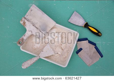Platering tools for plaster like plaste trowel spatula on green drywall plasterboard