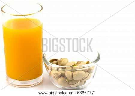 Pistachios In A Glass Plate And Glass Of Orange Juice Isolated On White