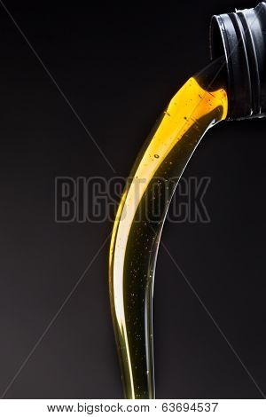 Motor oil pouring over black background