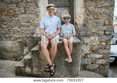 Happy father and son having rest outdoors in city