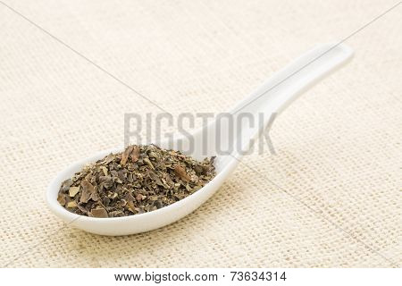 bladder wrack seaweed leaves on a white Chinese spoon against burlap canvas