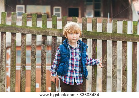 Outdoor portrait of a cute toodler boy resting in a countryside