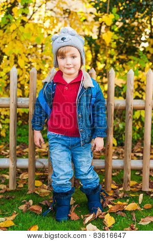 Autumn portrait of acute toddler boy wearing funny hat