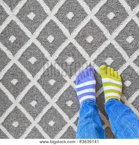 Legs In Mismatched Socks On Gray Carpet