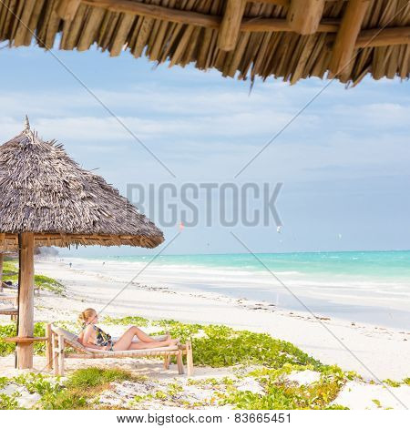 Woman sunbathing on tropical beach.
