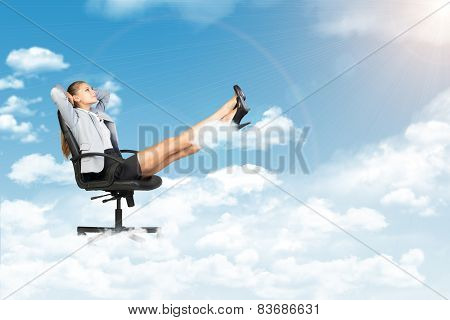 Businesswoman dreaming in clouds