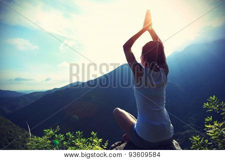 young fitness woman practice yoga at mountain peak rockvintage effect