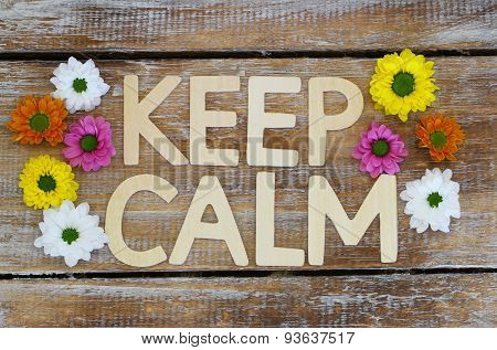 Keep calm written with wooden letters and Santini flowers