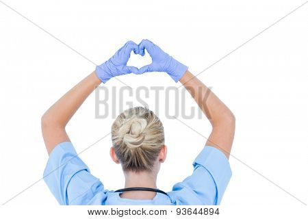 blond female doctor doing an heath sign against a white wall