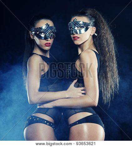two young sexy striptease dancer with mask