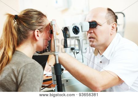 Adult optometry. male optometrist optician doctor examines eyesight of young woman patient in eye ophthalmological clinic 