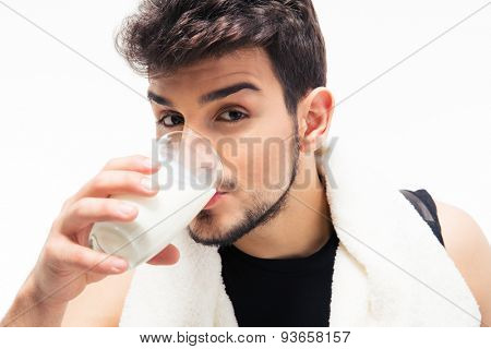Sports man with towel drinking milk isolated on a white background. Looking at camera