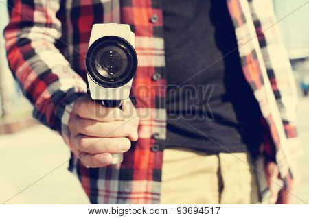 closeup of a young man pointing a Super 8 camera at the observer like it was a gun