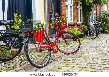 Retro vintage red bicycle on cobblestone street in the old town. Ribbe, Denmark