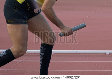 Athletic man running a relays the athletics track