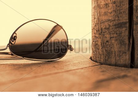 Mirrored Sunglasses Detail on the Wooden Background Close Up and Selective Focus. Fashion Concept in Sepia.