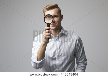 Portrait Of Male Criminologist With Magnifying Glass
