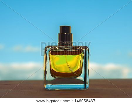 female yellow perfume bottle on blue background